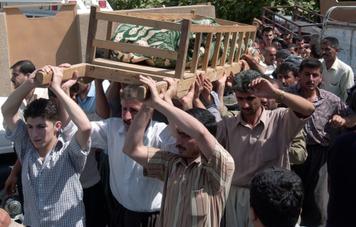 عراقيون يحملون أحد القتلى الى مثواه الاخير في بغداد امس (يحيى أحمد - أ ب)