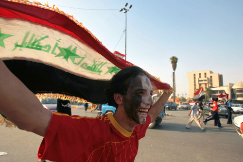 شاب عراقي يحتفل بفوز منتخب بلاده في بغداد امس (احمد الربيعي - أ ف ب)
