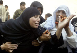 فلسطنية تنتحب بعد استشهاد أقاربها في غزة أمس (رويترز)