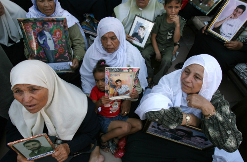 فلسطينيات يحملن صور أقربائهن المعتقلين خلال تظاهرة في غزة أمس (محمد عبد - أ ف ب)