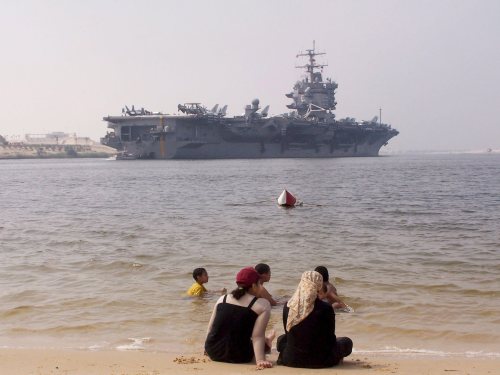 عائلة مصرية مقابل سفينة عسكرية أميركية في قناة السويس (أرشيف - إي بي أي)