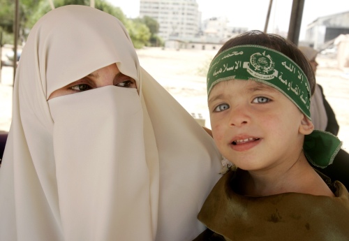 فلسطينية وطفلها خلال حفل تخريج عناصر من حماس أمس (ابراهيم أبو مصطفى - رويترز)