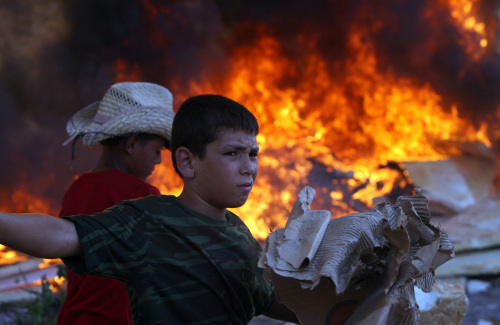 طفلان فلسطينيان يشاركان في إحراق أكوام من القمامة في غزة أمس (محمود حمس - أ ف ب)