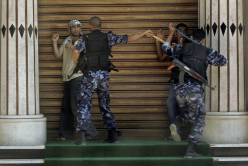 عنصران من القوة التنفيذية يعتقلان مناصرين لفتح في غزة أمس (حاتم موسى ــ أ ب)