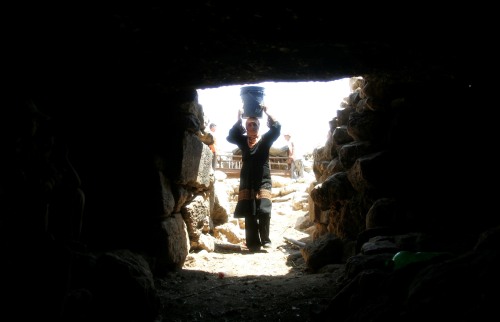 فلسطينية تحمل الماء في الخليل أمس (نايف هشلمون ــ رويترز)