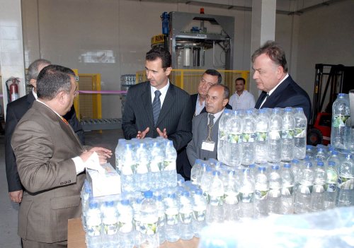 الأسد خلال افتتاحه مصنعاً للمياه المعدنية في طرطوس أمس (إي بي أي)