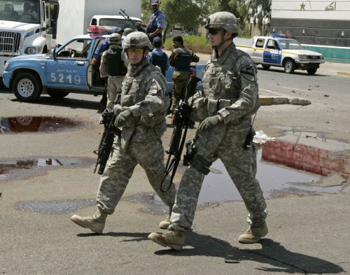 جنديان أميركيان بعد انفجار سيارة في بغداد أمس (محمود رؤوف محمود - رويترز)