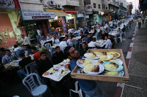 فلسطينيون على مائدة إفطار في أحد أسواق رام الله (أرشيف ـــ رويترز)