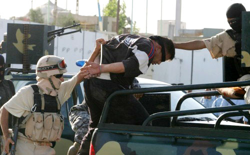 جندي عراقي يقتاد انتحارياً مفترضاً في كربلاء الشهر الماضي (مشتاق محمّد ـ رويترز)