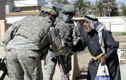 جندي أميركي يصافح عجوزاً عراقياً في المحموديّة جنوبي بغداد أمس (إبراهيم سلطان ـ رويترز)