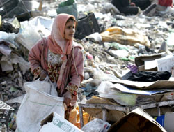 عراقيّة تنقّب بين أكياس القمامة في مدينة الصدر (وسام العقيلي ـ أ ف ب)
