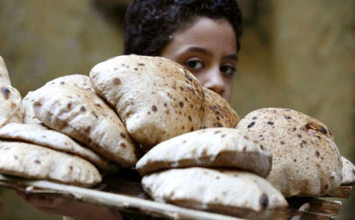 مصري يبيع الخبز في ظلّ ارتفاع الأسعار بعد رفع الدعم الحكومي عن الطحين (ناصر نوري ـ رويترز)
