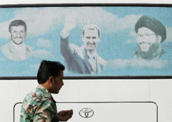 جندي سوري قرب حافلة عليها صور نجاد والأسد ونصر الله في دمشق الأسبوع الماضي (حسن عمّار ـــ أ ف ب)