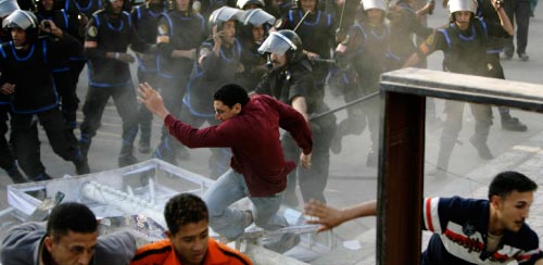 عناصر من الشرطة المصريّة يعتدون على المتظاهرين في المحلّة يوم الاثنين الماضي (ناصر ناصر ـــ أ ب)