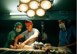 طبيب أوسترالي يجري عمليّة جراحيّة لجريح فلسطيني في أحد مستشفيات غزّة أمس (صهيب سالم ـــ رويترز)