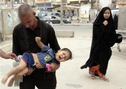 ينقل طفله المصاب في اشتباكات مدينة الصدر أمس (أحمد الربيعي ـــ أ ف ب)