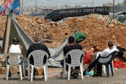 لبنانيّون يجلسون خلف السواتر الترابيّة على طريق المطار (هيثم الموسوي)