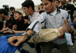 فلسطينيّون يحملون طفلاً أصابته رصاصات إسرائيليّة على معبر بيت حانون أمس (خليل حمرا ـــ أ ب)