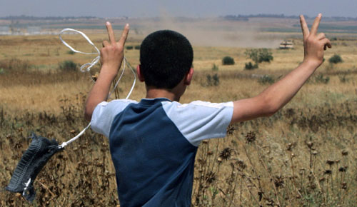 فلسطيني يرفع شارة النصر قبالة الآليّات الإسرائيليّة قرب معبر المنطار أمس (محمد عبد ـ أ ف ب)