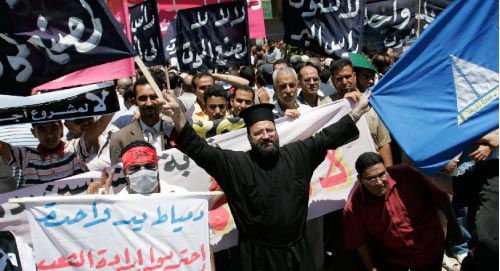 رجل دين قبطي يتصدّر تظاهرة في دمياط ضدّ إنشاء معمل الأسمدة الزراعيّة (ناصر نوري ـــ رويترز)