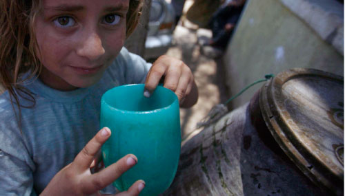 مصريّة تشرب مياهاً ملوّثة في الفيّوم (عمرو دلش ـــ رويترز)
