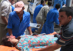 مسعفون عراقيون ينتشلون الجرحى في بعقوبة أمس (رويترز)