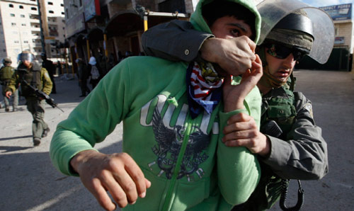 جندي إسرائيلي يلقي القبض على فلسطيني قرب القدس (أرشيف ــ رويترز)