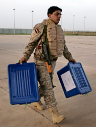جندي عراقي ينقل صندوقي اقتراع في الموصل (مايا آليروزو ـ أ ب)