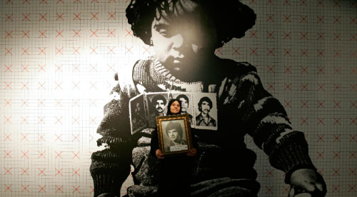 صبحيّة حجازي تحمل صورة لشقيقها الذي فُقد خلال الحرب الأهلية اللبنانيّة، في معرض مشترك أقيم في بيروت إحياءً للذكرى 35 للحرب (سينتيا كرم ــ رويترز) 