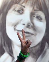 إيراني يرفع شارة النصر أمام ملصق لندا آغا سلطان في باريس العام الفائت (أرشيف ــ أ ف ب)