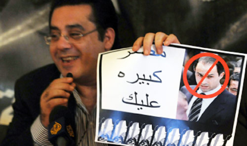 رئيس حزب الغد أيمن نور يحمل ملصقاً معارضاً لترشيح جمال مبارك للرئاسة (محمد عبد الغني ــ رويترز)