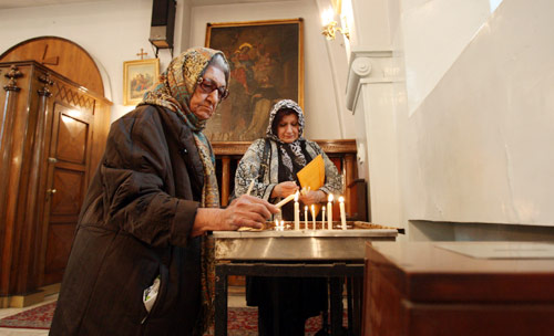 مؤمنتان خلال قداس عيد الميلاد في كنيسة الأرمن الكاثوليك في طهران يوم السبت 
(وحيد سالمي ــ أ ب)