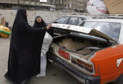 عراقيّتان تستقلّان سيّارة أجرة في وسط بغداد الشهر الماضي (إريك دي كاسترو ـــ رويترز)
