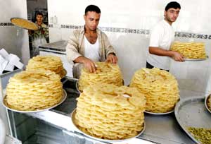 عراقيون يحضرون الحلويات في سوق النجف (رويترز)