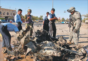 جندي أميركي وشرطي عراقي يتفحصان آثار انفجار سيارة مفخخة في كركوك أمس ( ا ب)