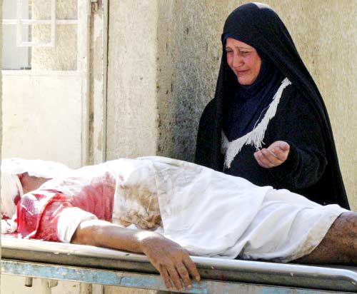 عراقية تنتحب قرب جثة زوجها القتيل في هجوم في بعقوبة أمس ( رويترز)