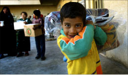 طفل عراقي يحمل مساعدة من الصليب الأحمر العراقي في بغداد أمس (أ ف ب)