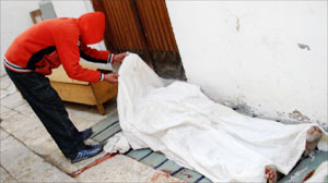 فتى عراقي يتفقّد جثمان أحد ضحايا العنف في العراق في مسجد في بغداد أمس (رويترز)