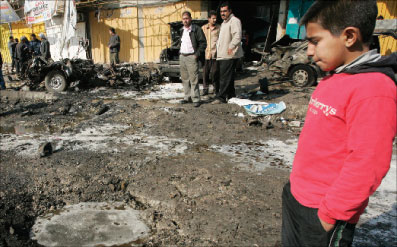 فتى عراقي ينظر إلى فجوة خلّفتها عبوة ناسفة في بغداد أمس (رويترز)