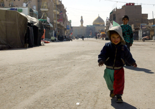 طفل عراقي يلعب في أحد شوارع النجف أمس (أ ف ب)