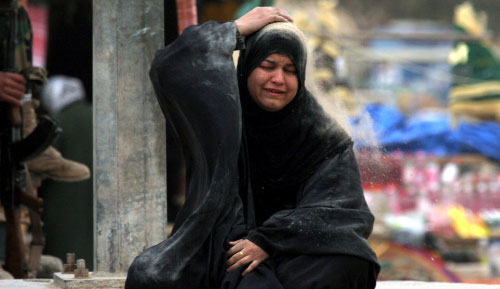 زوجة أحد ضحايا تفجيرات سوق الصدريّة تنتحب خلال التشييع في النجف أمس (أ ب)
