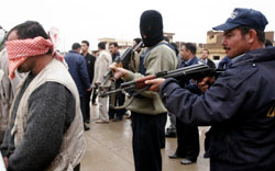 شرطيّان عراقيّان يحرسان مشتبهاً بهم في كركوك أمس (أ ب)