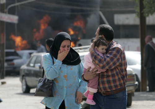 عائلة عراقيّة تنتحب بعد التفجير في موقف السيّارات في حيّ الكرّادة في بغداد أمس (رويترز)