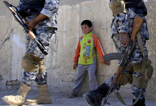 طفل عراقي أثناء دوريّة للقوّات الخاصّة العراقية في مدينة الصدر في بغداد أمس (أ ف ب)