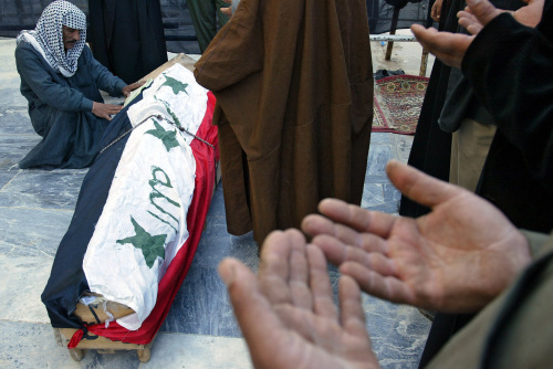 عراقيّون يصلّون على جثمان أحد ضحايا تفجيرات النجف أمس (أ ف ب)