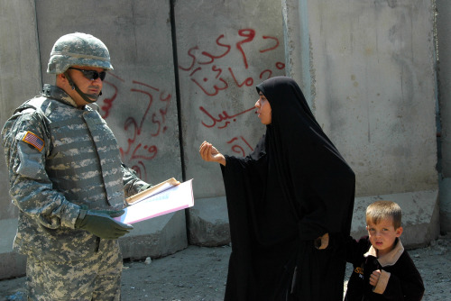 عراقيّة تجادل جنديّاً أميركيّاً في حيّ الجامعة في بغداد أمس (أسعد محسن - أ ب)