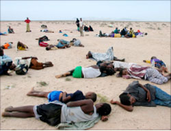 لاجئون صوماليّون يرتاحون عند شاطئ مدينة أهروار اليمينيّة الأحد (خالد عبدالله - رويترز)