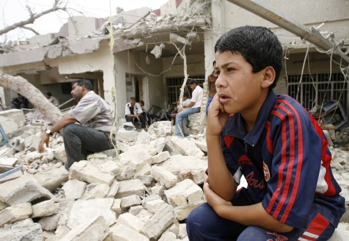 طفل عراقي أمام البيوت المدمّرة في بغداد أمس (علي جاسم - رويترز)