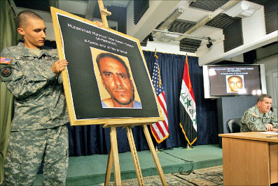 جندي أميركي يعرض صورة «الأمير» في تنظيم القاعدة في العراق محمد المشهداني خلال الإعلان عن مقتله في بغداد أمس (علي حيدر - أ ف ب)
