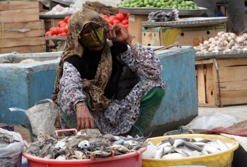 ايرانية تبيع الأسماك في مدينة بندر عباس الايرانية أمس (حسن سربخشيان - أ ب)